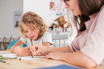 photo of child with autism coloring with parent