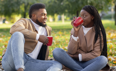 couple on date drinking coffee in park