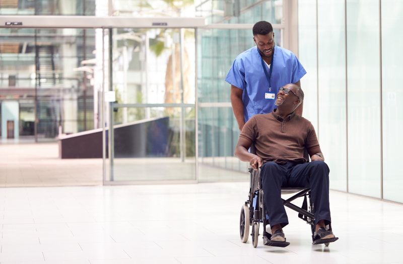 photo of nurse transporting patient in wheelchair